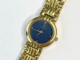 une image représentant une montre en or avec un cadran bleu sur un fond blanc