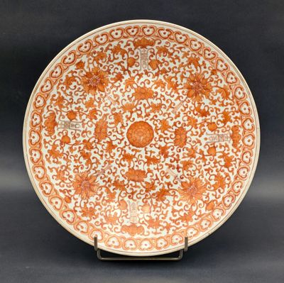 une assiette orange et blanche ornée d'un motif floral