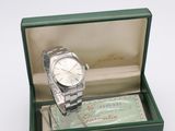 a watch in a green box on a white surface