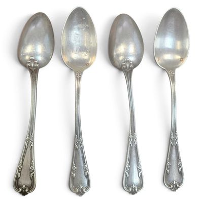 four spoons are lined up in a row on a white surface