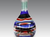 un vase en verre orné d'un motif rouge, blanc et bleu
