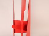 an image of a red metal sculpture on a white surface