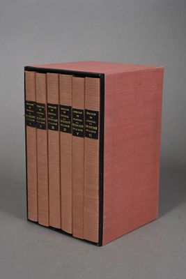 the three books are lined up in a row on a gray surface