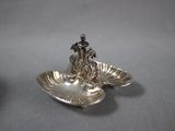 a silver plate with a bird on it on a table