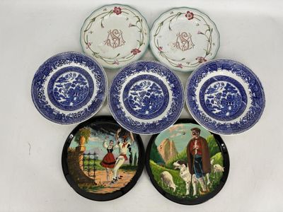 six assiettes bleues et blanches sur lesquelles figurent un homme et un chien