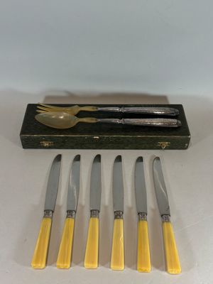 quatre couteaux et une fourchette dans une boîte contenant un couteau