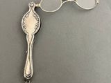 a silver spoon and a pair of glasses on a table