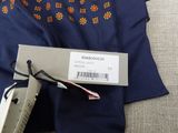a tie with a tag on it next to a pair of scissors