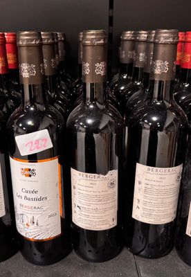 Des bouteilles de vin rouge sont alignées sur une étagère dans un magasin