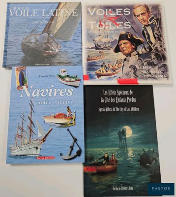 quatre livres posés sur une table blanche, avec un bateau dans l'eau