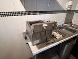 une cuisine avec un évier et un grille-pain posé sur le plan de travail