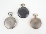 three different types of pocket watches on a white surface