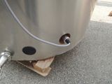 a large metal tank with a hose attached to it ' s side