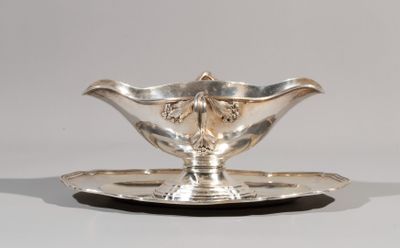 a silver plate with a flower on it on a white surface