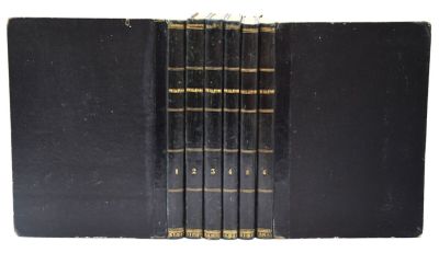 cinq livres noirs aux tranches dorées sont empilés les uns sur les autres