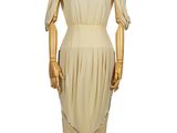 an image of a mannequin wearing a beige dress on a wooden stand
