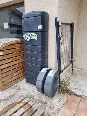 une poubelle et une autre poubelle placées à l'extérieur d'un immeuble