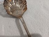une cuillère en argent ornée d'une feuille, posée sur une table