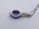 a close up of a necklace with a blue stone on a chain
