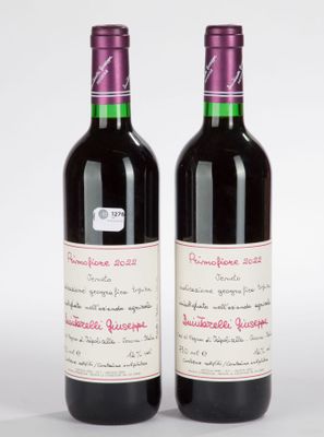 deux bouteilles de vin rouge posées l'une à côté de l'autre sur une surface blanche