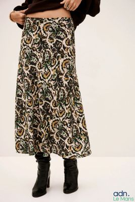 Cette femme porte une jupe à motifs floraux.