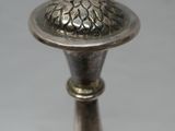 a silver vase with a flower on top of it