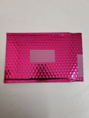 a pink metallic foil envelope with a window on top of it