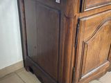 a wooden cabinet with a marble top on a tiled floor