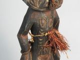 wooden statue of a man with a large head and a small face
