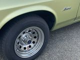 un gros plan d'une voiture verte avec une jante chromée
