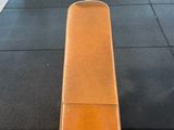 a bench in the middle of a gym with a row of chairs in the background