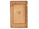 an old book sitting on top of a white table next to a white wall