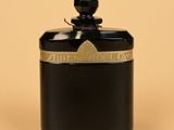 an image of a black glass jar with a gold lid