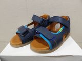 blue leather sandals with a bow on the side of them on a white box