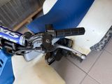 a blue and white moped with a blue seat and handlebars