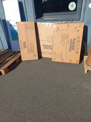 deux cartons posés par terre à côté d'une palette en bois