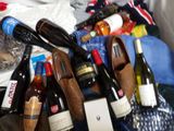 many bottles of wine and a pair of shoes on a bed
