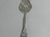 an antique silver spoon on a white surface with a silver handle