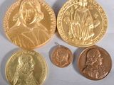 deux médailles d'or et deux pièces d'argent sur un fond blanc