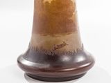 a brown vase with a brown base on a white surface