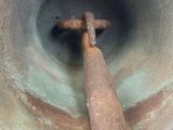 a large metal bell with a wooden handle in the middle of it