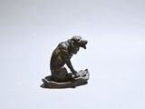 a statue of a monkey sitting on top of a rock