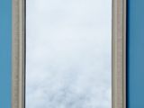 the mirror is hanging on the wall above the blue wall