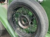 a green antique car parked on the side of the road