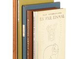trois livres sont empilés sur une surface blanche