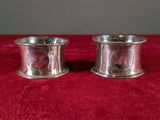 two silverplated napkin holders on a red cloth