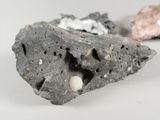two rocks with holes in them on a white surface