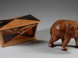 un petit éléphant en bois à côté d'une petite boîte en bois