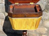 a small wooden box on a stand with a wooden top