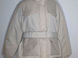 jacket on a mannequin stand with a white wall in the background